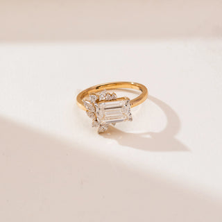 Front view of Emerald Cut Cluster Diamond Ring in 14KT white gold, featuring a central emerald-cut diamond with marquise and round cluster accents in a floral-inspired design.