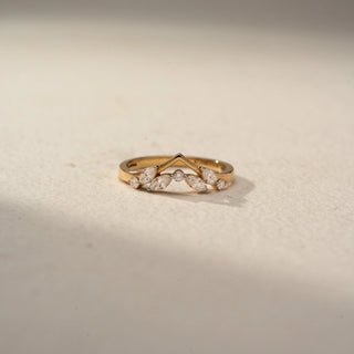 Front view of a chevron diamond band in 14 KT Yellow Gold, featuring marquise-cut and round lab-grown diamonds arranged in a delicate leaf-inspired V-shaped design, displayed against a beige backdrop.