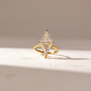Front view of Kite-Shaped Diamond Solitaire Ring in 14KT Yellow Gold, featuring a vertically set kite-cut center diamond. Set on a soft beige surface, the design reflects modern elegance and sharp brilliance.
