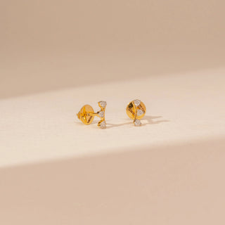 Angled view of Delicate Triple Spark Diamond Earrings in 14KT Yellow Gold, featuring three round lab-grown diamonds.