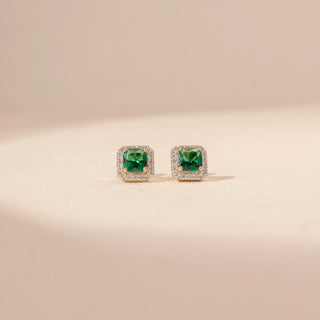 Front view of 14KT yellow gold square green gemstone stud earrings, framed by a sparkling diamond halo.