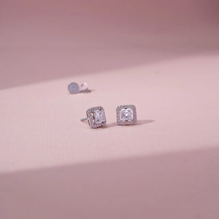 Angled view of princess-cut lab-grown diamond halo stud earrings in 14 KT White gold, featuring princess-cut centre diamonds surrounded by square pavé-set diamond halos in a timeless elegant design.