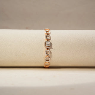 Front view of a diamond bracelet in 14 KT Rose Gold, featuring repeating circular pavé-set diamond motifs linked in a graceful linear design, displayed against a soft beige backdrop.
