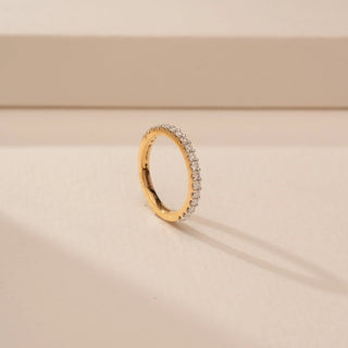 Angled view of a 14KT Yellow Gold diamond ring with a full diamond-set band featuring round diamond accents.