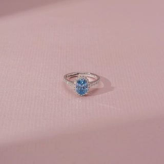 Top view of Oval Blue Diamond Halo Ring in 14KT White Gold, featuring a blue oval diamond with a sparkling halo.