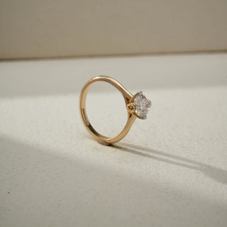 Side view of a yellow gold solitaire ring featuring a round brilliant-cut diamond in a classic prong setting, highlighting its elevated profile and timeless elegance.