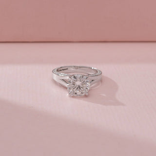 Close up view of a 14KT White Gold diamond ring, featuring a round centre diamond and a sleek sculpted band.