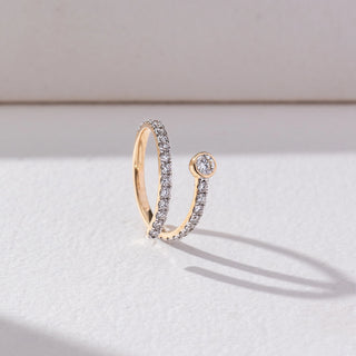 Side view of Open Wrap Diamond Ring in 14KT Yellow Gold, featuring a bezel-set round lab grown diamond with pavé band. Set on a beige backdrop, the design highlights structure and modern elegance.
