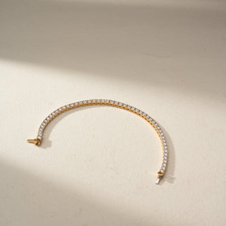 Top view of a lab-grown diamond tennis bracelet in 14 KT yellow gold, featuring a continuous row of round brilliant diamonds in a classic and elegant design.