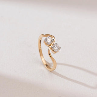 Angled view of Radiant Golden Duo Diamond Ring in 14KT yellow gold, featuring two round brilliant-cut diamonds set on a sleek, flowing S-shaped bypass band.
