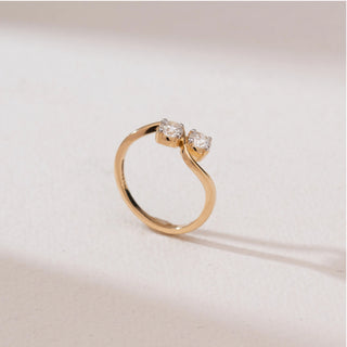Side angle view of Radiant Golden Duo Diamond Ring in 14KT yellow gold, featuring two round brilliant-cut diamonds set on a sleek S-shaped bypass band.