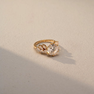 Side view of a cushion-cut solitaire ring in 14 KT Yellow Gold, featuring a cushion-cut lab-grown diamond in a classic four-prong setting, displayed against a beige backdrop.