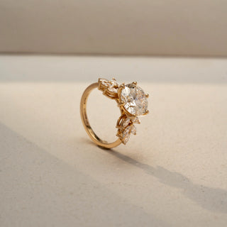 Angled view of a cushion-cut solitaire ring in 14 KT Yellow Gold, featuring a cushion-cut lab-grown diamond in a classic four-prong setting, displayed against a beige backdrop.