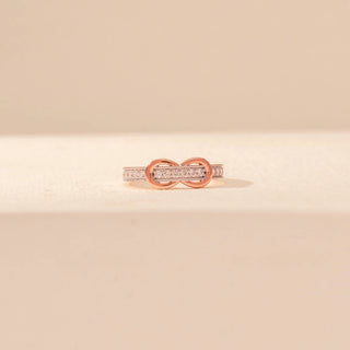 Front view of Infinity Diamond Ring in 14KT Rose Gold, featuring intertwined loops and a pavé diamond band.