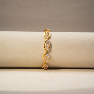 Front view of a yellow gold lab-grown diamond bracelet featuring marquise-shaped open links with pavé diamonds, displayed on a neutral jewellery cushion.