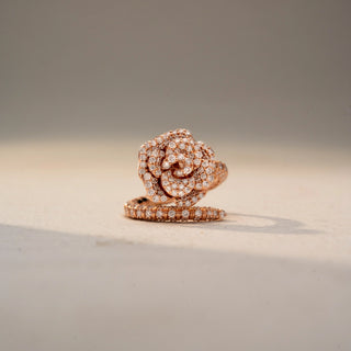 Front view of a floral diamond statement ring in 14 KT Rose Gold, featuring a rose-inspired cluster of round lab-grown diamonds and a diamond-accented split shank, displayed against a beige backdrop.