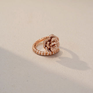 Side view of a floral diamond statement ring in 14 KT Rose Gold, featuring a rose-inspired cluster of round lab-grown diamonds and a diamond-accented split shank, displayed against a beige backdrop.