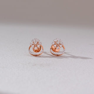 Front view of floral diamond stud earrings in rose gold, featuring pear-shaped lab-grown diamonds in a blooming cluster above a curved diamond-studded base. Set on a soft neutral backdrop, they reflect graceful elegance.