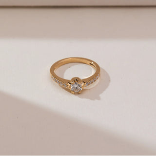 Top view of Modern Collet Pavé Diamond Ring in yellow gold, featuring a round lab-grown diamond in a sleek collet setting with pavé diamond accents along the band, displayed on a soft beige backdrop.