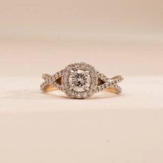Front view of Reia’s 14 KT Yellow Gold Elegant Twisted Halo Diamond Ring. It highlights the round-cut central diamond within a shimmering halo and the fluid, intertwining pavé-set twisted band.