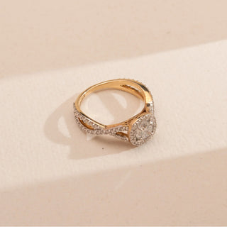 Top-down view of Reia’s 14 KT Yellow Gold Elegant Twisted Halo Diamond Ring. It highlights the shimmering halo setting and the intricate, intertwined pavé-set twisted band on a cream backdrop.