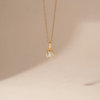 Front view of a 14KT Yellow Gold diamond pendant with a round bezel-set centre diamond and a simple bail.