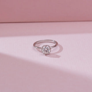 Front view of the Minimalist Six Prong Diamond Ring in 14KT white gold, featuring a round solitaire diamond secured in a classic six-prong setting on a sleek polished band against a soft pink background.