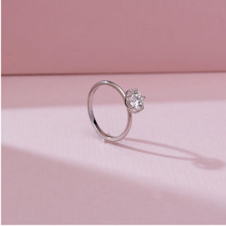 Side angled view of the Minimalist Six Prong Diamond Ring in 14KT white gold, showcasing a round solitaire diamond in a classic six-prong setting on a sleek polished band against a soft pink background.