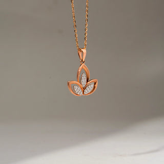 Side view of a rose gold floral pendant necklace featuring three petal-shaped diamond accents in an openwork design, suspended from a delicate chain against a soft neutral backdrop.