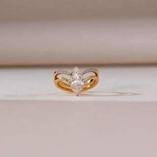 Front view of Marquise Bypass Split Diamond Ring in yellow gold, featuring a marquise-cut lab-grown diamond framed by a split bypass band with pavé diamond accents, displayed on a soft beige surface.