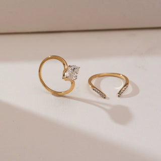 Side view of Marquise Bypass Split Diamond Ring in yellow gold, featuring a marquise-cut lab-grown diamond with an open split bypass band accented by pavé diamonds, displayed on a soft beige surface.