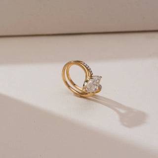 Angled side view of Marquise Bypass Split Diamond Ring in yellow gold, highlighting a marquise-cut lab-grown diamond set on an open split bypass band with pavé diamond accents, placed on a beige backdrop.