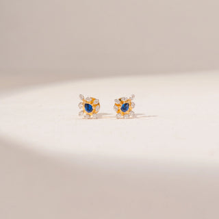 Front view of Blue Gemstone Diamond Earrings in 14KT Yellow Gold, featuring oval blue gemstones and round lab-grown diamonds.