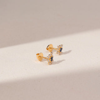 Side view of Blue Gemstone Diamond Earrings in 14KT Yellow Gold, featuring oval blue gemstones and round lab-grown diamonds.
