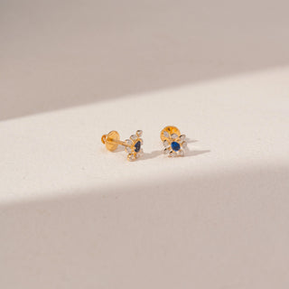 Angled view of Blue Gemstone Diamond Earrings in 14KT Yellow Gold, featuring oval blue gemstones and round lab-grown diamonds.