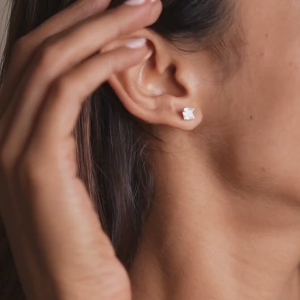 Princess-cut lab-grown diamond stud earring by Réia in 14KT White Gold, worn on the ear, shown in soft natural lighting for a minimal, elegant everyday look.

