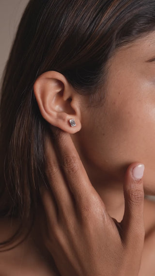 Emerald-cut lab-grown diamond stud earring by Réia in 14KT White Gold, worn on the ear, captured in soft natural light for an elegant everyday look.

